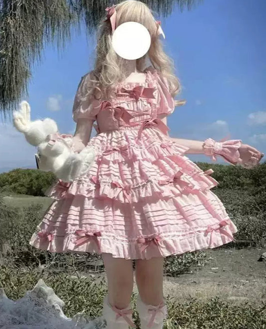 Person in a pink dress holding a white plush toy outdoors with trees and blue sky in the background